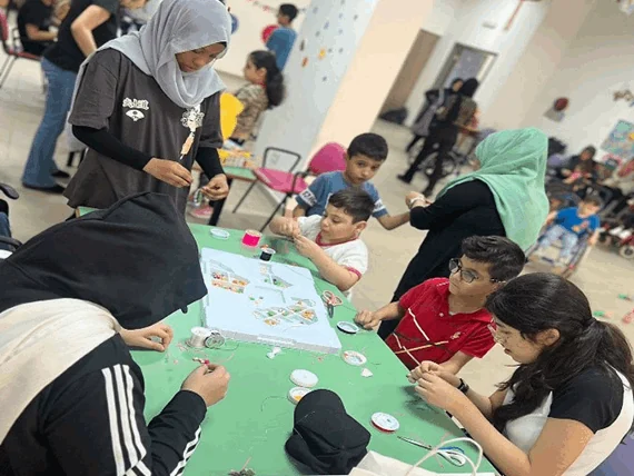Students and adults taking part in a table activity during a community service visit